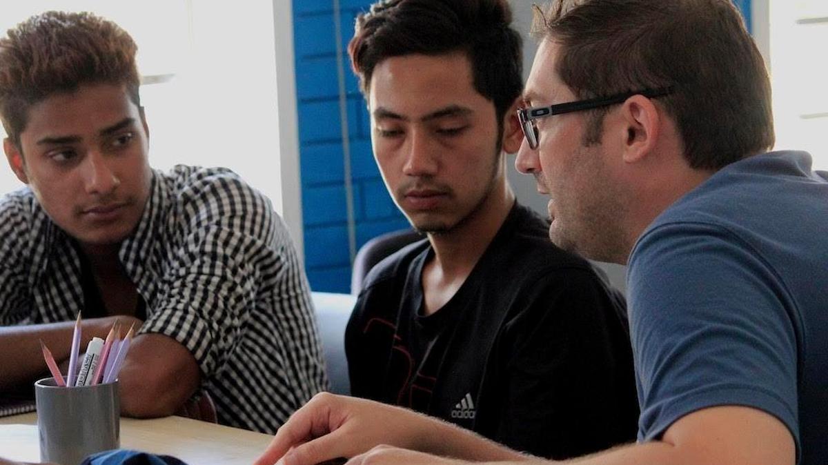 CloudFactory CEO Mark Sears, right, works with employees based in Nepal. CloudFactory announced on Friday, June 9, that it was expanding its presence in Durham.