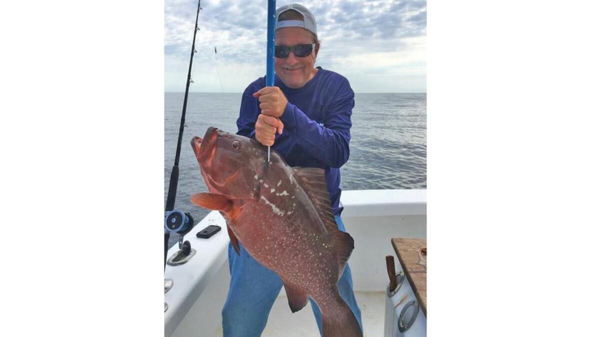 Robert Dean holds up the state record red grouper that he caught off the coast of Carolina Beach in June.