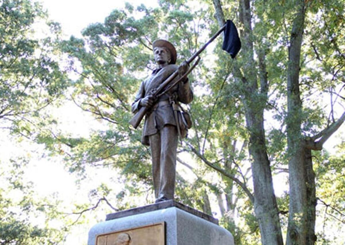 Members of The Real Silent Sam Coalition placed a black garment on the barrel of the statue’s gun Monday, Oct. 12, 2015. Between 30 and 40 members of the coalition marched from McCorkle Place to Memorial Hall where they briefly disrupted the University Day proceedings to decry the memorial to Confederate soldiers of the university and racism they say persists on campus.