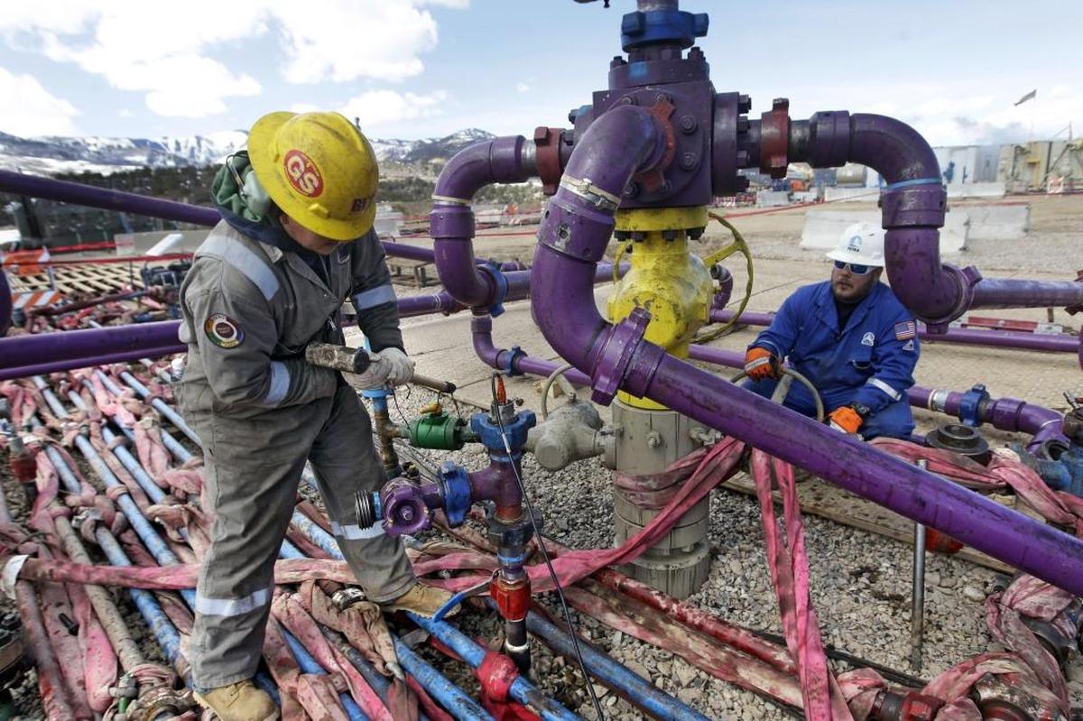 In this March 29, 2013 photo, workers tend to a well head during a hydraulic fracturing operation at an Encana Oil & Gas (USA) Inc. gas well outside Rifle, in western Colorado.