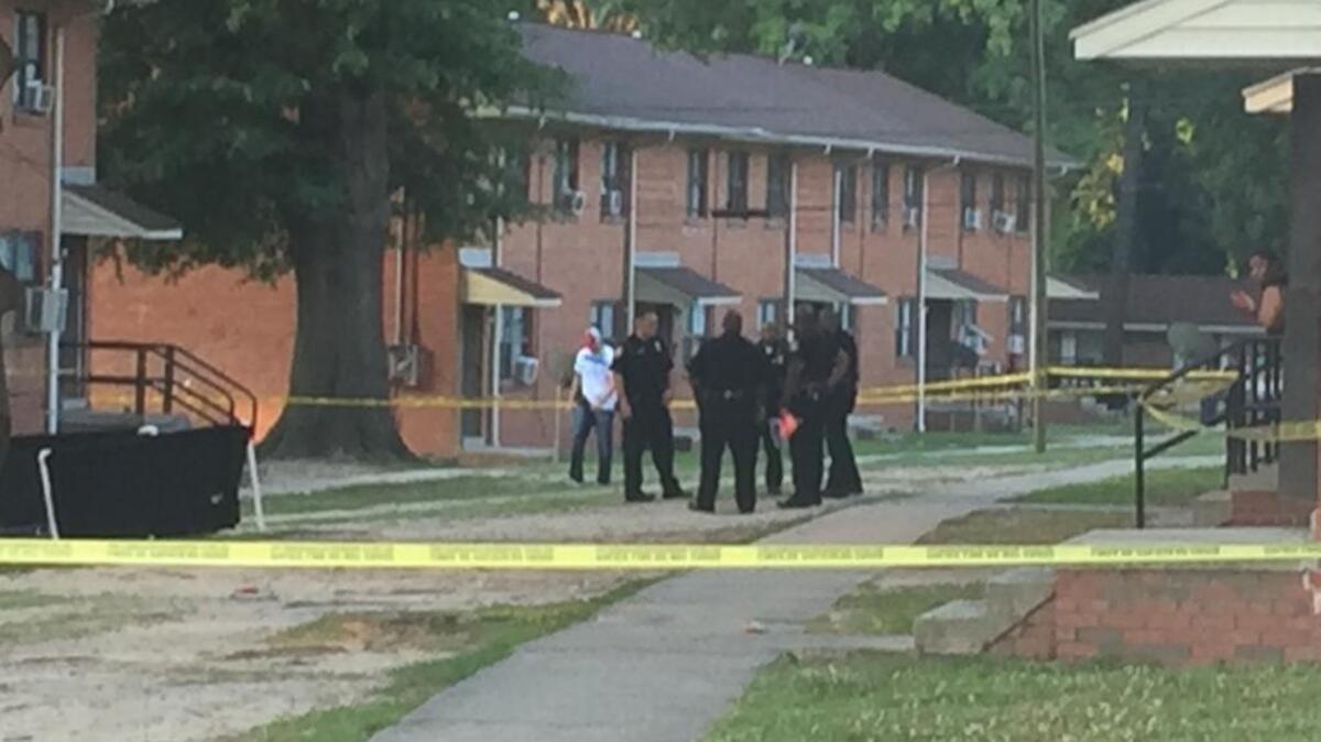 Durham police confer near the spot where a man was found shot to death about 6 a.m. Friday, June 30, 2017, in a courtyard at the McDougald Terrace housing project in Durham, N.C.