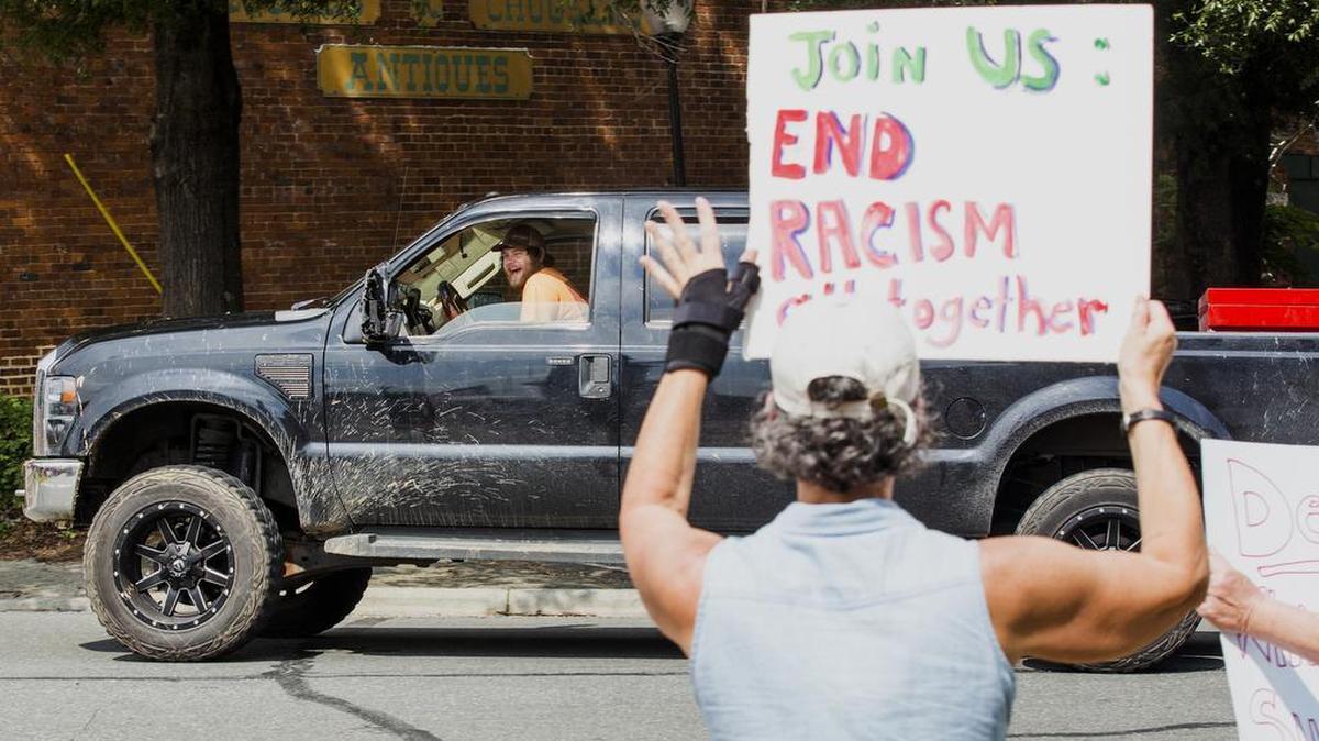 A driver in Pittsboro reacts as a group of protesters gather around the Confederate monument at the Chatham County Courthouse in Pittsboro Sunday for a vigil commemorating the victims of the protest-turned-deadly in Charlottesville, Va., on Saturday.
