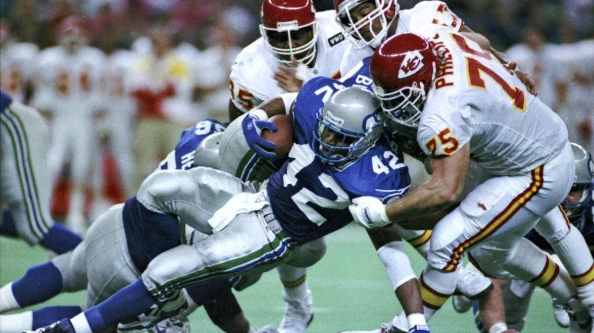 In this Nov. 22, 1992, file photo, Kansas City Chiefs' Tom Sims, rear left, Chris Martin, rear right, and Joe Phillips, right, tackle Seattle Seahawks running back Chris Warren during an NFL football game in Seattle. In 2013 five former Chiefs players sued the team, claiming it hid the risks of head injuries. The plaintiffs were Leonard Griffin, Chris Martin (and his wife), Joe Phillips, Alexander Louis Cooper and Kevin Porter. All said they were suffering from brain damage, specifically chronic traumatic encephalopathy, or CTE.