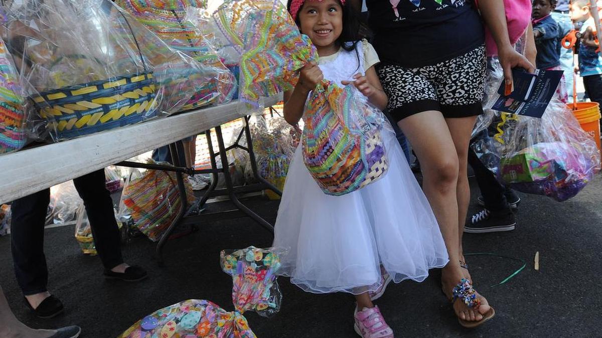 Allison Salos-Reyes wears her Easter finest and smiles after getting her Easter basket at the annual Community Easter event at the Durham Rescue Mission.