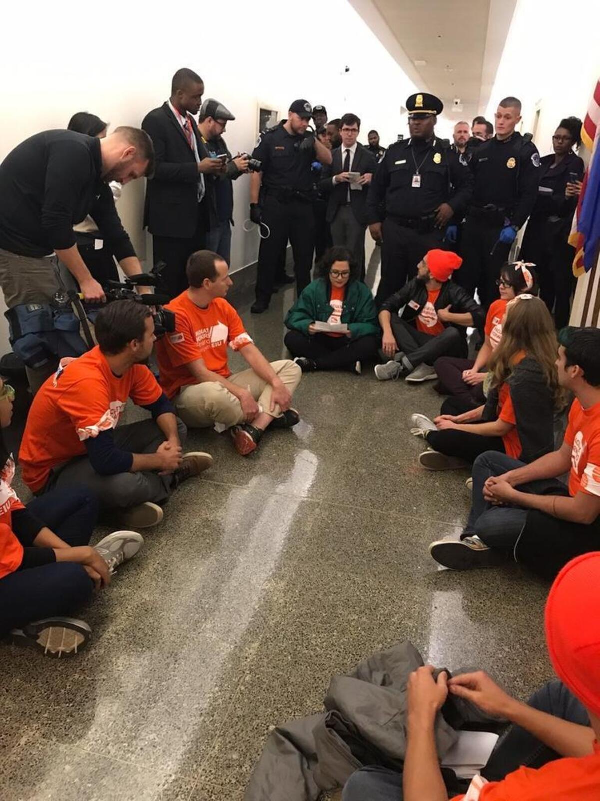 Duke Ph.D. student Laura Jaramillo (center, green jacket) prepares to be arrested by U.S. Capitol Police along with eight other people protesting a proposed tax-law rewrite outside U.S. House Speaker Paul Ryan’s office on Tuesday.