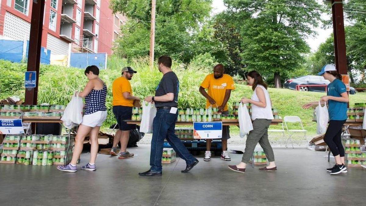 Volunteers walk an assembly line creating meal and reading kits for Durham area students on June 21, 2017, in Durham, NC.