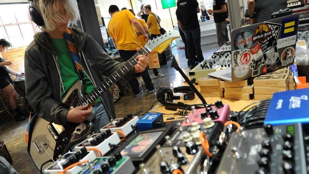 Atticus Batson is playing a guitar with synthesizers during Moogfest 2017, at the American Tobacco Campus.