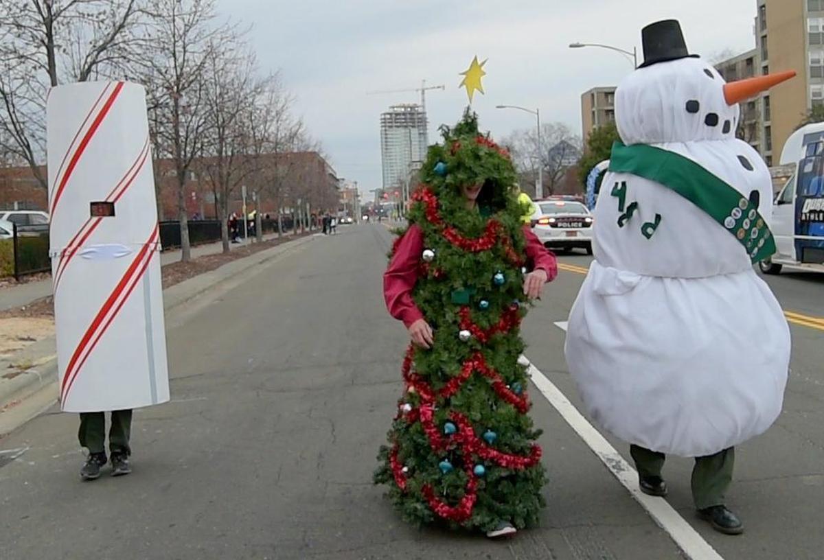 A candy cane, a Christmas tree, and a snowmen stroll down Main Street during the 2017 Durham Holiday Parade.
