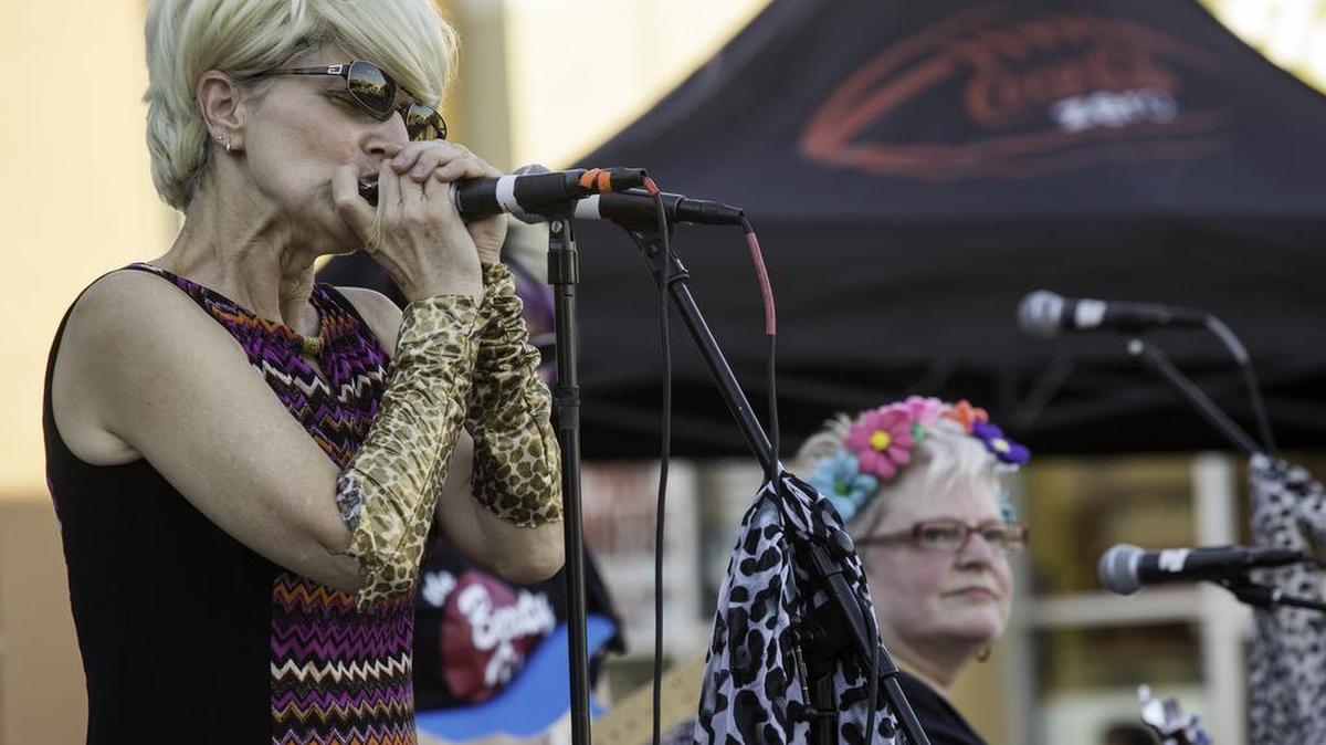 Beauty Operators band member Sandee Washington plays the harmonica during the band’s appearance at Northgate Mall’s Music on the Plaza event Friday.