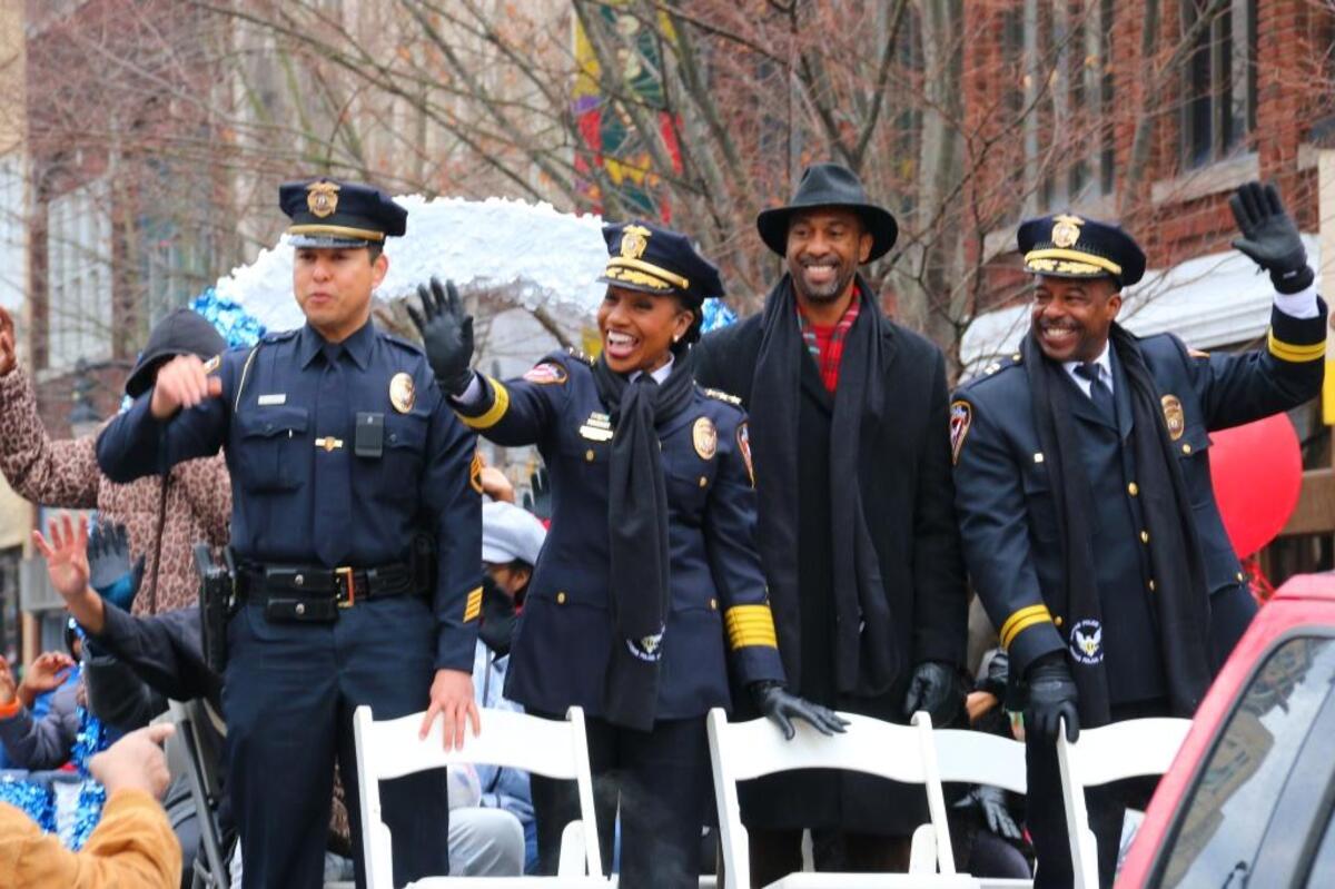 Durham Housing Authority CEO Anthony Scott, third from left, rides in the Durham Holiday Parade on Dec. 2 with Durham Police Department Chief C.J. Davis, second from left, and DPD officers.