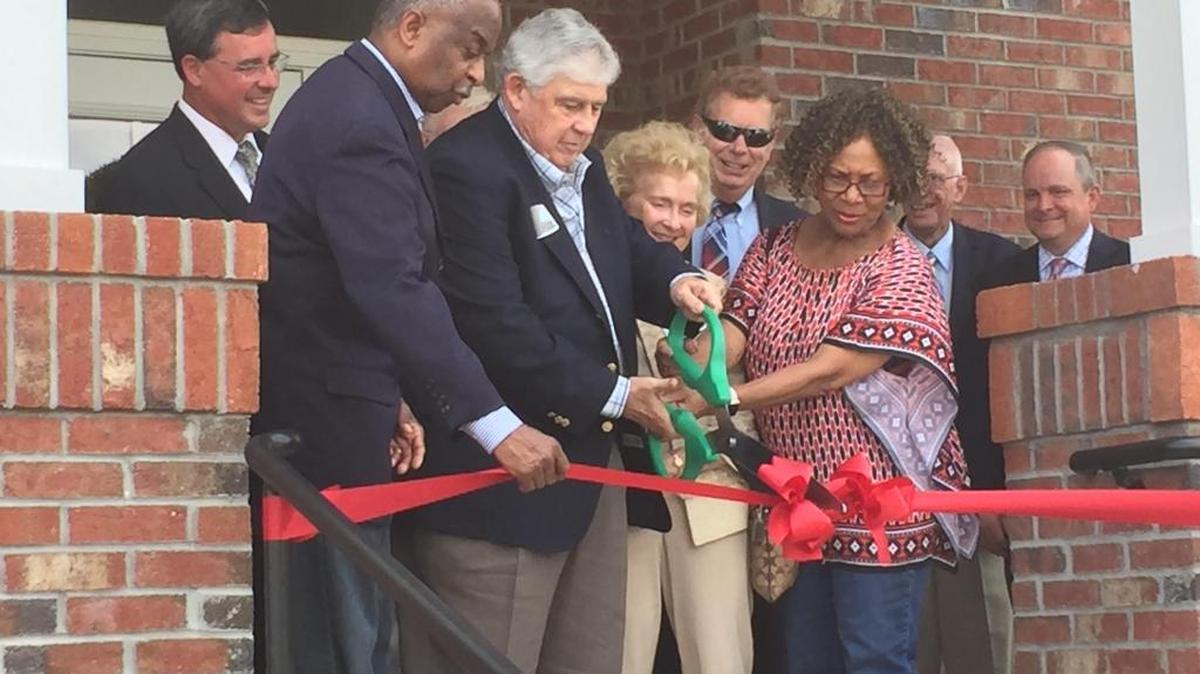 James Ball and wife Wendy Ball (center) are joined by Mayor Bill Bell (left) and Mayor Pro Tem Cora Cole-McFadden (right) during a ribbon-cutting at the new Ball Family Student Housing Center on Saturday.