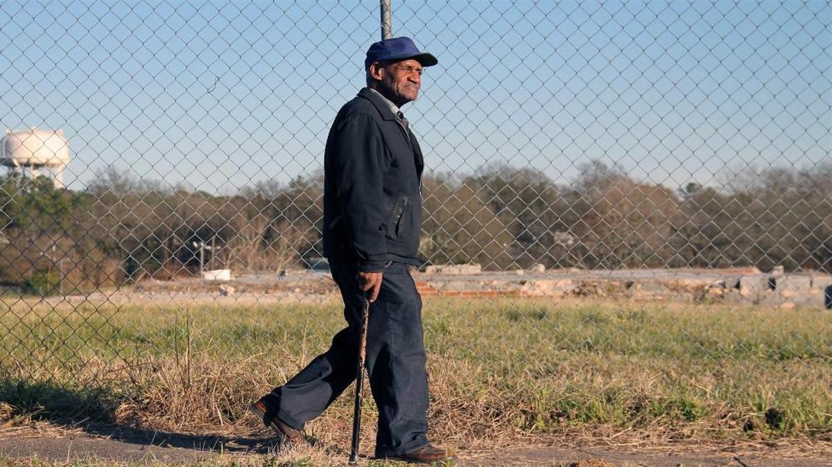 "I don't know why they tore it down," Arthur Royster, 81, says as he walks past the fenced-in remain of the Fayette Place public housing project in the Hayti district on Saturday, Feb. 5, 2016. "Everybody's about the damn dollar," says the retired housekeeper at N.C. Central University. "Money's good; you need it to survive. "But people take the money and that's all they think about."