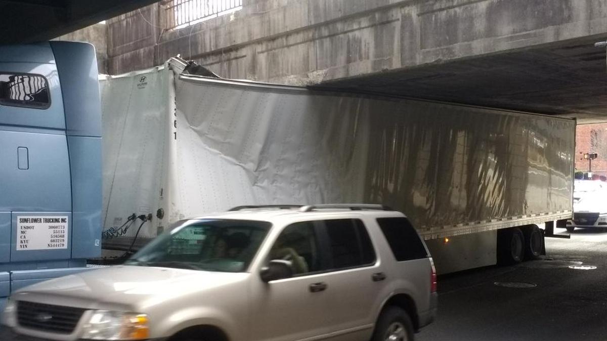 A truck and trailer are shown stuck underneath the railroad bridge near the intersection of Roxboro and Pettigrew streets in Durham on Wednesday, Jan. 10, 2018.
