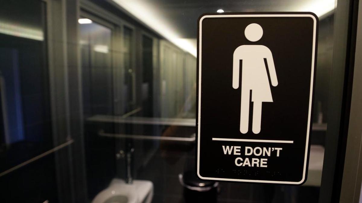 In this May 12, 2016 photo, signage related to the state’s HB2 law is seen outside a restroom at 21c Museum Hotel.