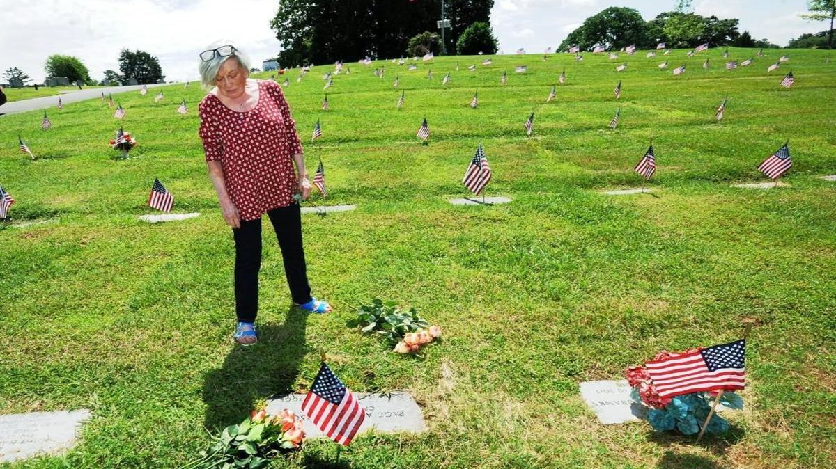 Nadia Anderson stands by the grave of her husband, Page Anderson, an Army captain who served in Vietnam and who died in 2008. Nadia regularly brings fresh roses to her husband’s grave. “I loved him from the first day we met and forever,” she says.