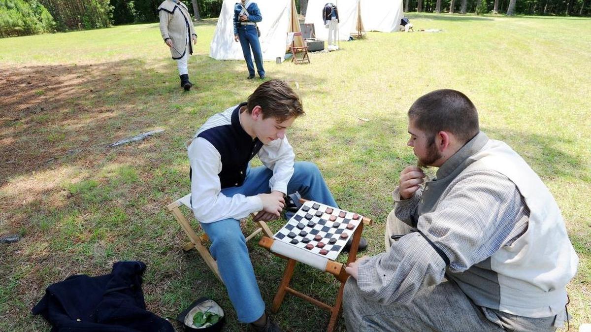The Herald-Sun | Bernard Thomas Union soldier Chris Williams (left) plays checkers with Confederate soldier Aaron Moses (right) during the Memorial Day military timeline at Bennett Place.