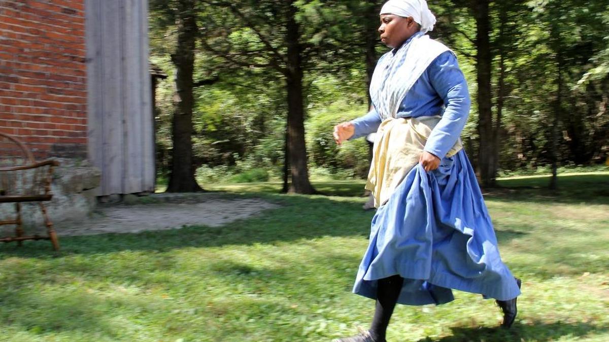 Nicole Moore, a museum educator from Virginia Beach, hurries across the yard to get back to her cooking at the Horton Grove slave quarters. Hundreds visited the Historic Stagville State Historic Site in Durham County in 2013 to see how enslaved and free black people prepared meals during antebellum times.