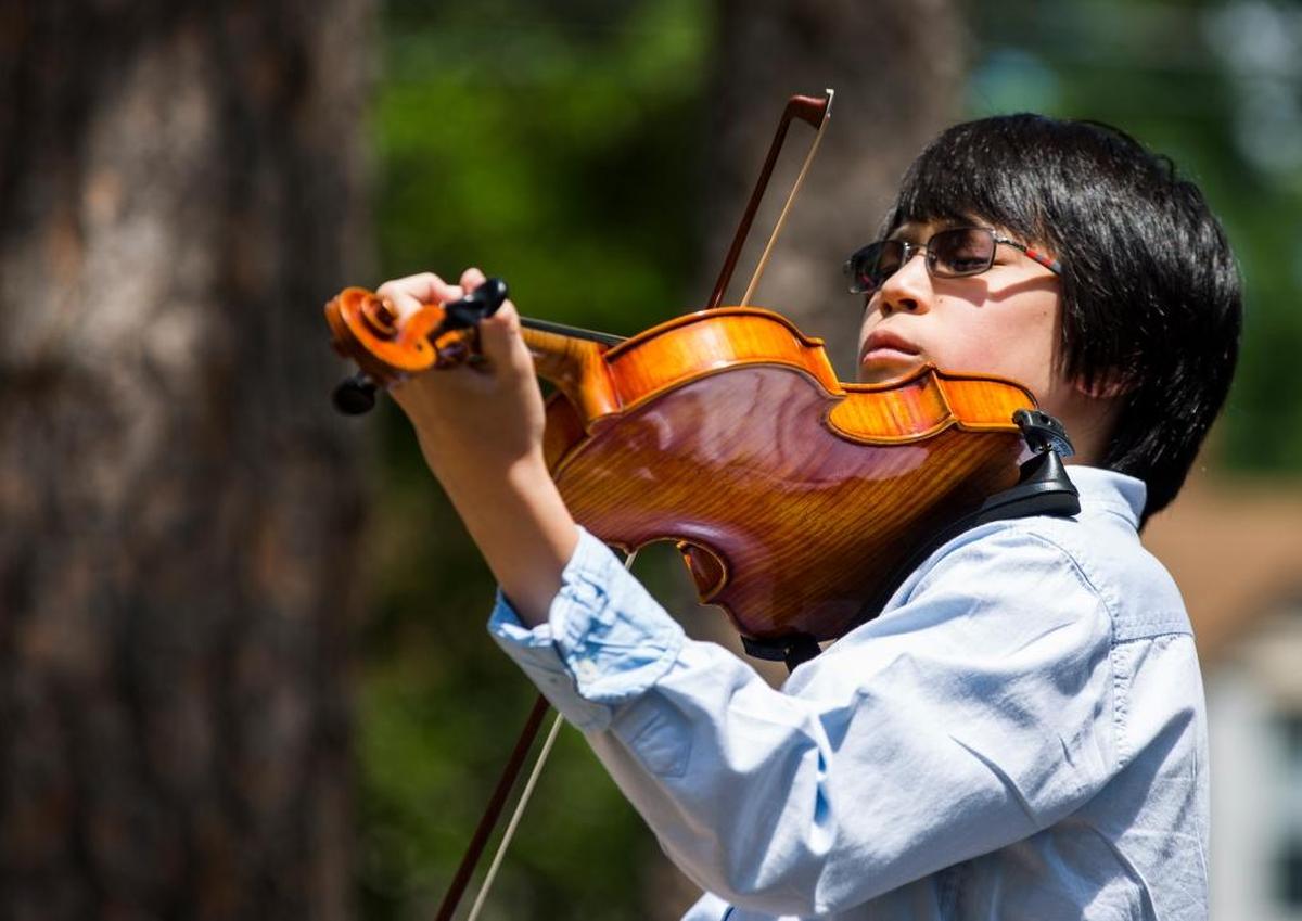 Jayon Felizarta performs during a ceremony at Oval Park dedicating a bench to Dorothy Kitchen's contributions to music education as founder and director of the Duke University String School, on Sunday April 30, 2017, in Durham, NC. The bench is nestled in the twelfth 'history grove' created by communities in partnership with the Museum of Durham History celebrating individuals or groups who have helped shape Durham.