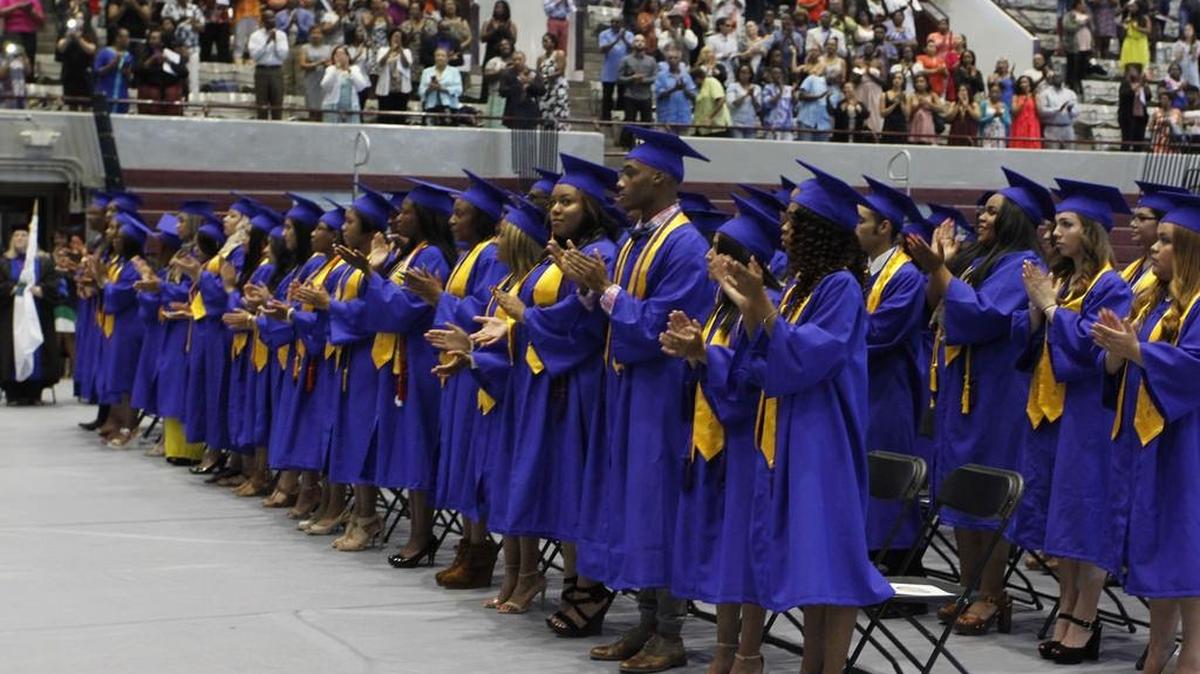 Students stand and applaud during City of Medicine Academy’s 2016 graduation.