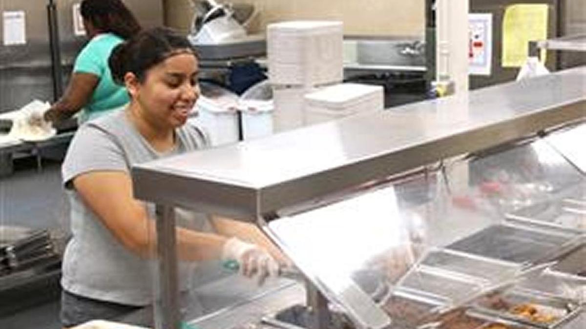 A server at a Durham elementary school dishes up a hot meal.