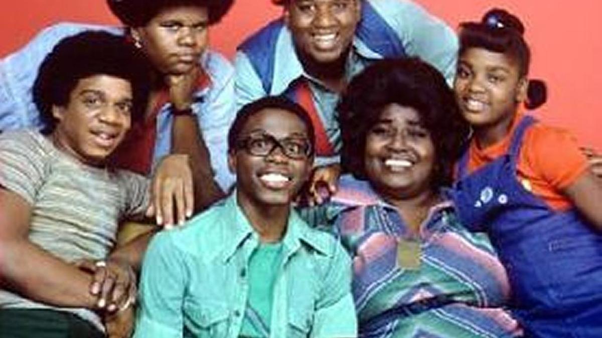 Pictured is the cast and crew of the 1970s hit TV comedy “What’s Happening,” featuring Ernest Thomas as Roger (Raj) pictured here wearing glasses.