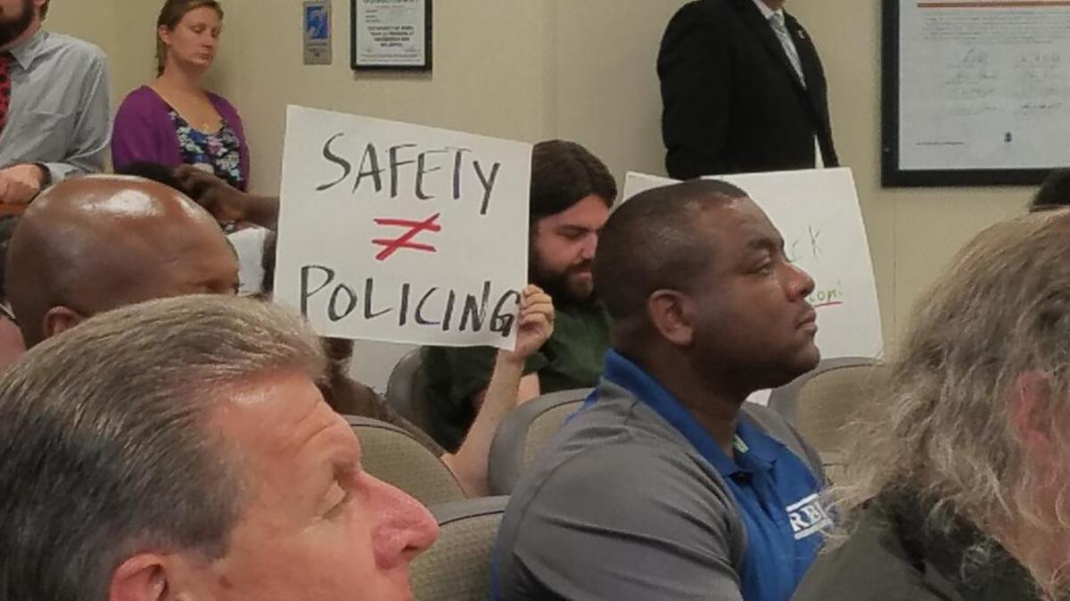 A protester holds up a sign opposing school resource officers in schools at a City Council work session on Thursday, July 27, 2017.