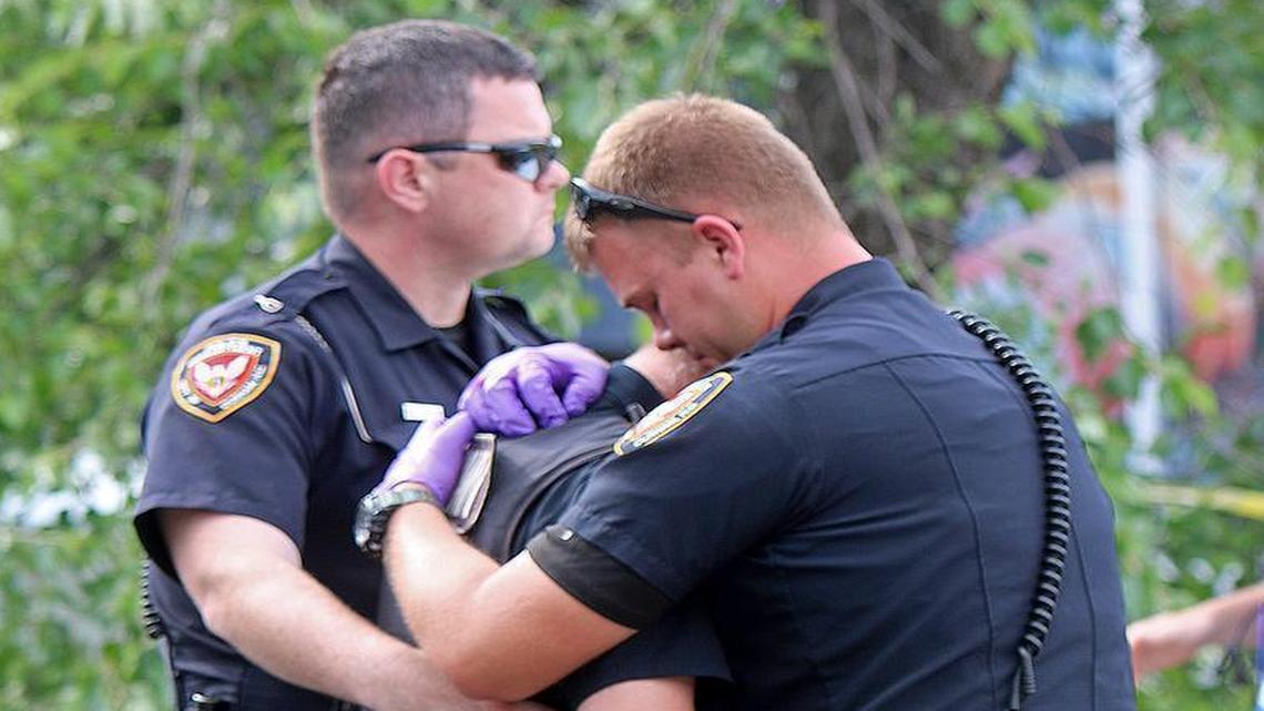Durham Police Department officers, pictured from left, B. Taylor, B. Johnson and R. Preston, console each other early Sunday evening at the scene of the shooting death of a boy, 7, near Guess Road’s Tokyo Express restaurant. The first names of the officers were not available.