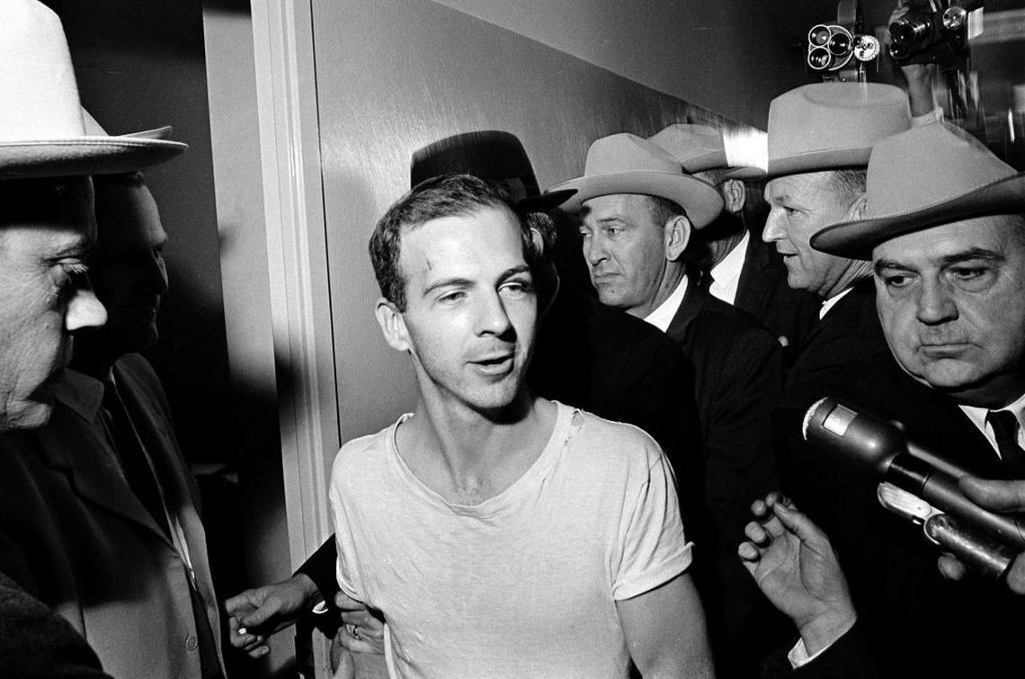 Surrounded by detectives, Lee Harvey Oswald talks to the press as he is led down a corridor of the Dallas police station for another round of questioning in connection with the assassination of U.S. President John F. Kennedy, November 23, 1963.