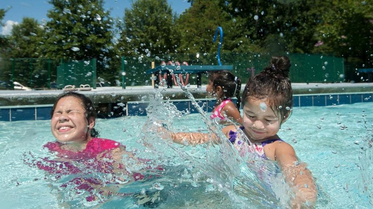 Shirley Pulido, 10, and Kelyn Contreras, 2, splash in the water at Hillside Pool on July 14, 2016 in Durham.