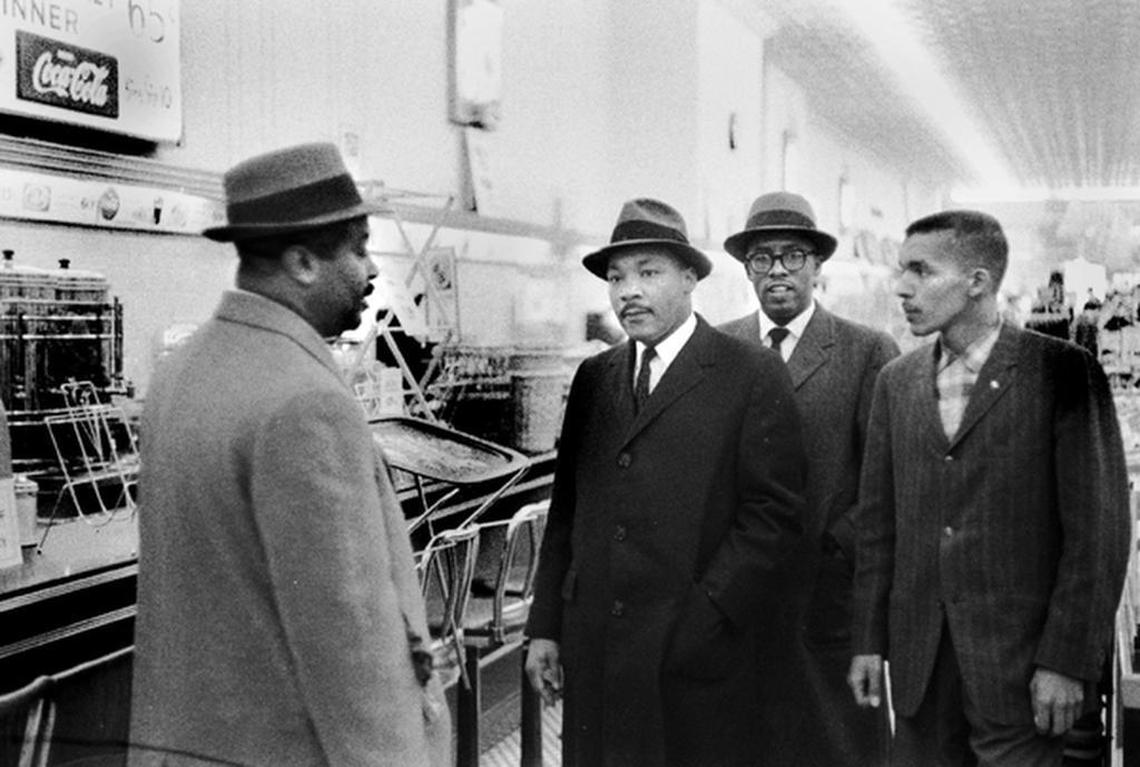 Pictured from left, Ralph Abernathy, the Rev. Martin Luther King Jr., Asbury Temple Methodist Church pastor Rev. Douglas Moore and N.C. Central University student Lacy Streeter visit the then-segregated lunch counter at Woolworth’s in downtown Durham on Feb. 16, 1960.