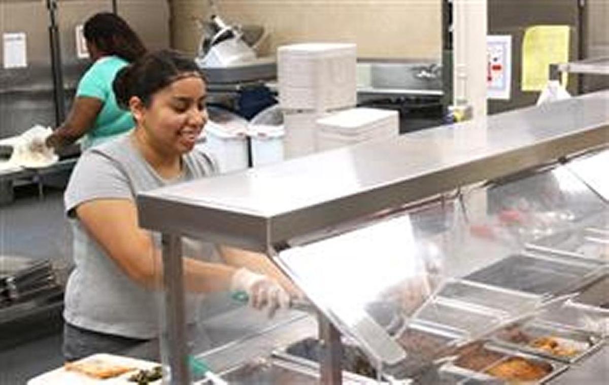 A server at a Durham elementary school dishes up a hot meal.