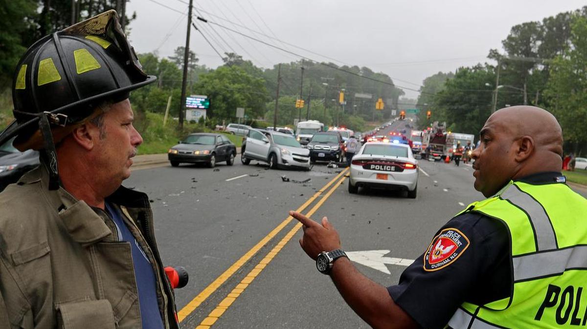 A Durham police officer and a firefighter are pictured at a crash scene at the intersection of Stadium Drive and North Duke Street. The city may raise  police and firefighters pay to help fill vacancies and reduce turnover.