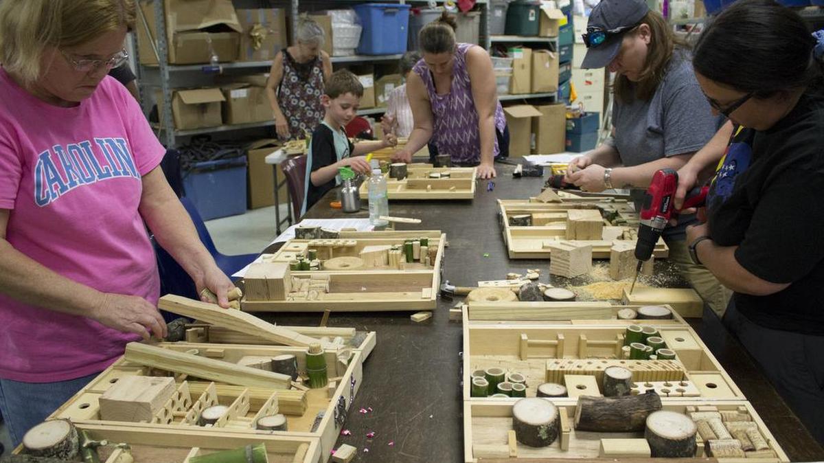 Gail Plaisance, left, of Raleigh, and Sarah Beard, right, of Durham, work on their pollinator hotels Sunday at The Scrap Exchange. The hotels attract bees and other pollinators that help flowers and vegetables grow.
