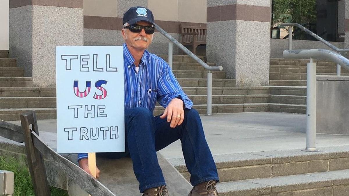 Mike Mannshardt, 70, a retired teacher from Pittsboro, N.C., waits to hear from speakers at an anti-Trump rally in Raleigh on Saturday, April 15, 2017. Mannshardt and other demonstrators want Trump to release his income tax returns.