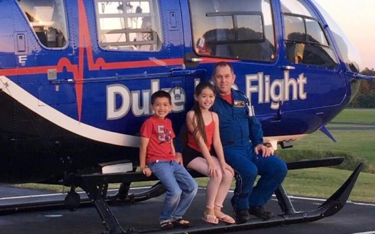 Pilot Jeff Burke poses for a photo with his daughter Isabelle and son Jason in front of a Duke Life Flight helicopter. Burke was one of four people who died Sept. 8 in a Life Flight crash.