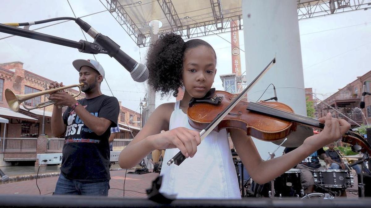 Kidznotes’ Sofia Gee plays the violin with jazz artist Al Strong (left) during the Art of Cool concert at the American Tobacco Campus Saturday.