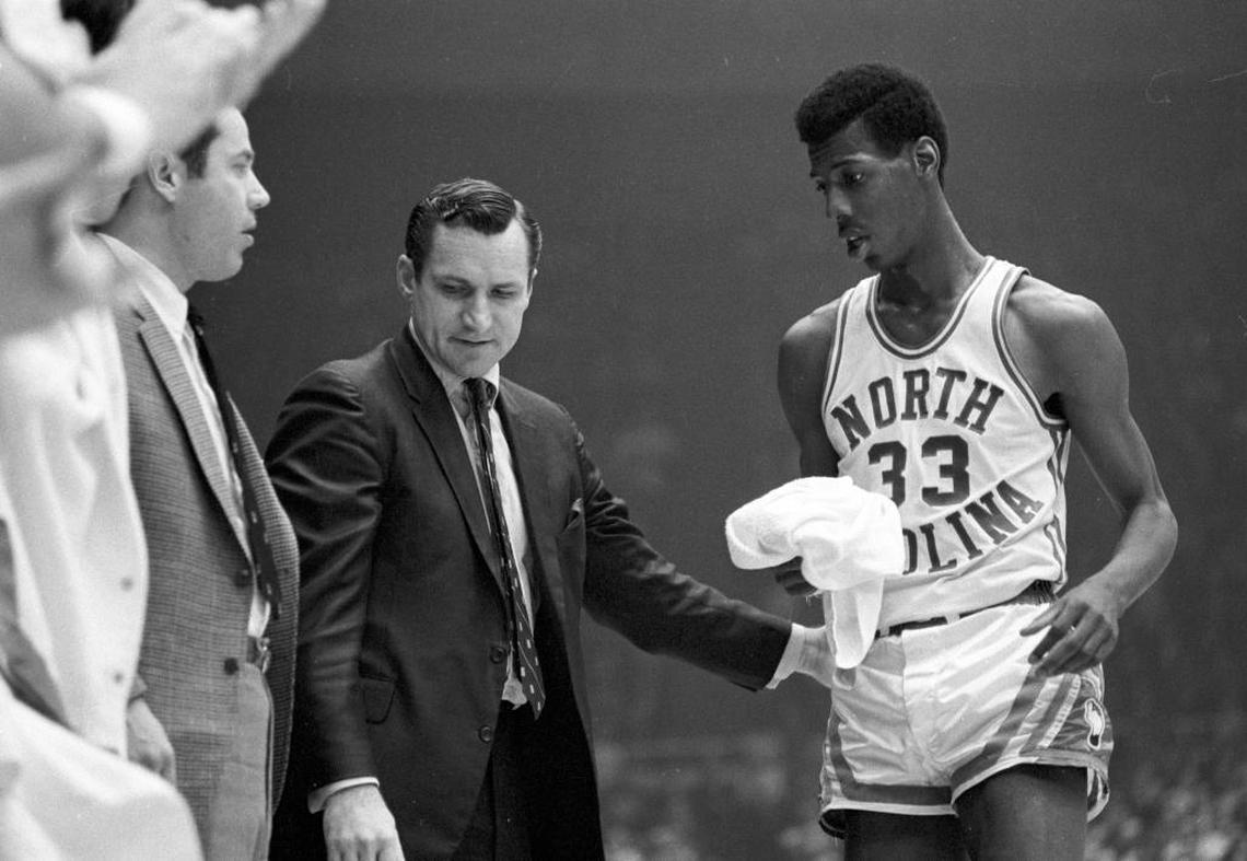 Dean Smith (left), shown here with Charlie Scott in the 1969 ACC tournament, had to win a recruiting battle with Davidson and coach Lefty Driesell for Charlie Scott.