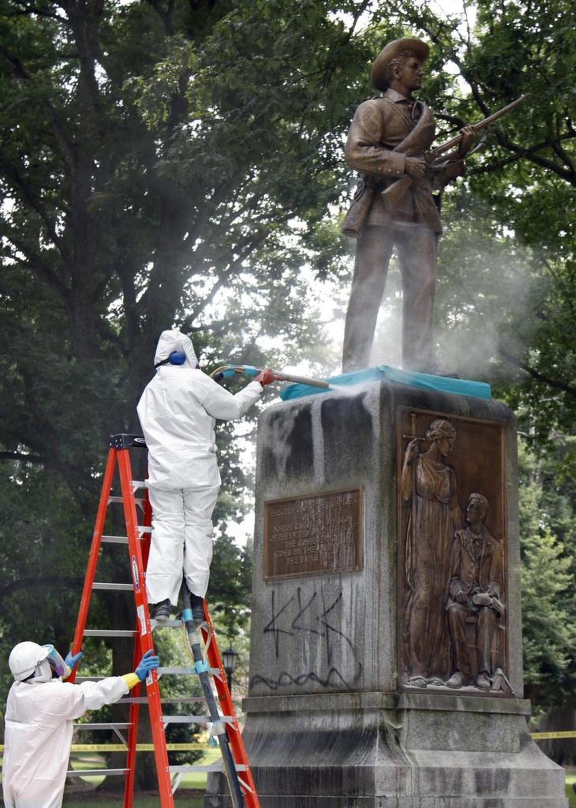A CCI Environmental Services worker blasts one face of the sandstone base of the Silent Sam monument on the UNC-CH campus removing black acrylic spray paint Tuesday, July 7, 2015