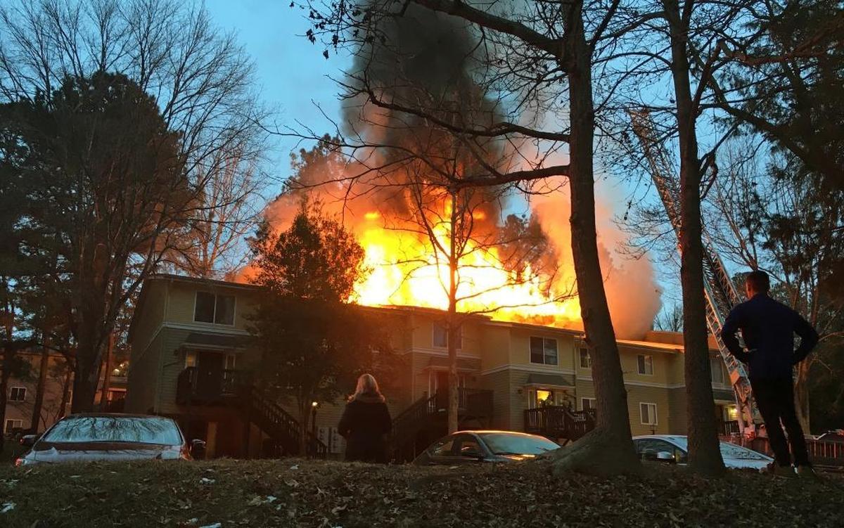 Residents watch Monday, Jan. 8, 2018, as a thick fire burns through eight second-story apartments of Building L at The Villages of Chapel Hill on Smith Level Road in Carrboro. Eight apartments on the building’s ground floor were damaged by smoke and water, fire officials said.