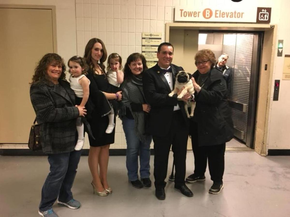 Esteban Florias (in tuxedo, center right) holds “Biggie,” who’s getting a pet from owner Carolyn Koch, far right. Pictured, from left, are Jeannie Grejda and Jennifer Farias hold the Farias’ twin daughters, with Maureen Esposito.