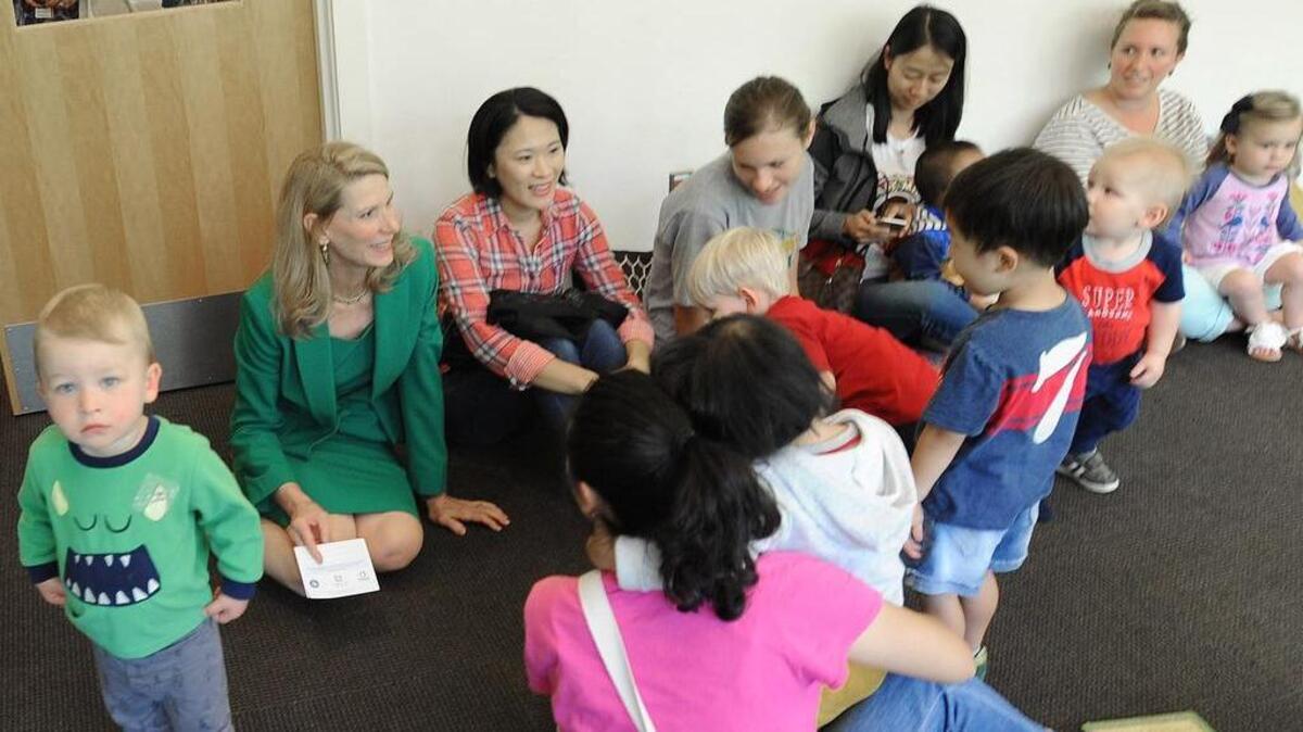 North Carolina first lady Kristin Cooper, left, sits with parents and children in an activity room of the Chapel Hill Public Library after announcing grants to local libraries.