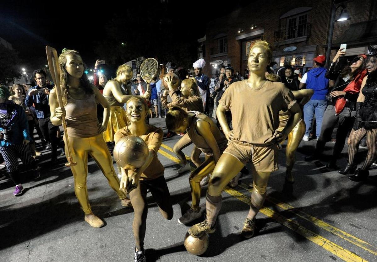 Athletic gold statues parade down Franklin Street Tuesday night during the annual Homegrown Halloween celebration. Police estimated 15,000 people turned out for the event, one of the smallest crowds for the All Hallow’ Eve tradition.