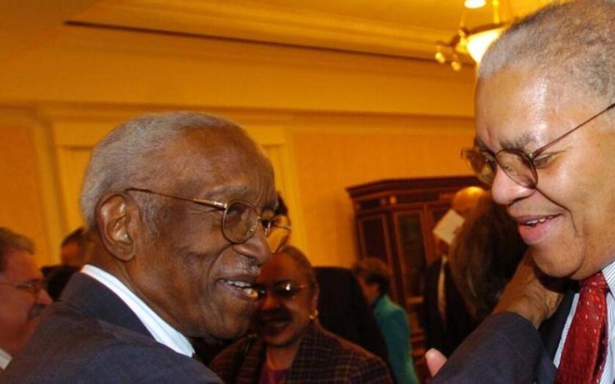 Samuel Dubois Cook, right, Duke University’s first black professor, greets renowned historian John Hope Franklin at a campus dinner in this Duke University file photo of uncertain date. Cook died on May 29, 2017 at age 88.