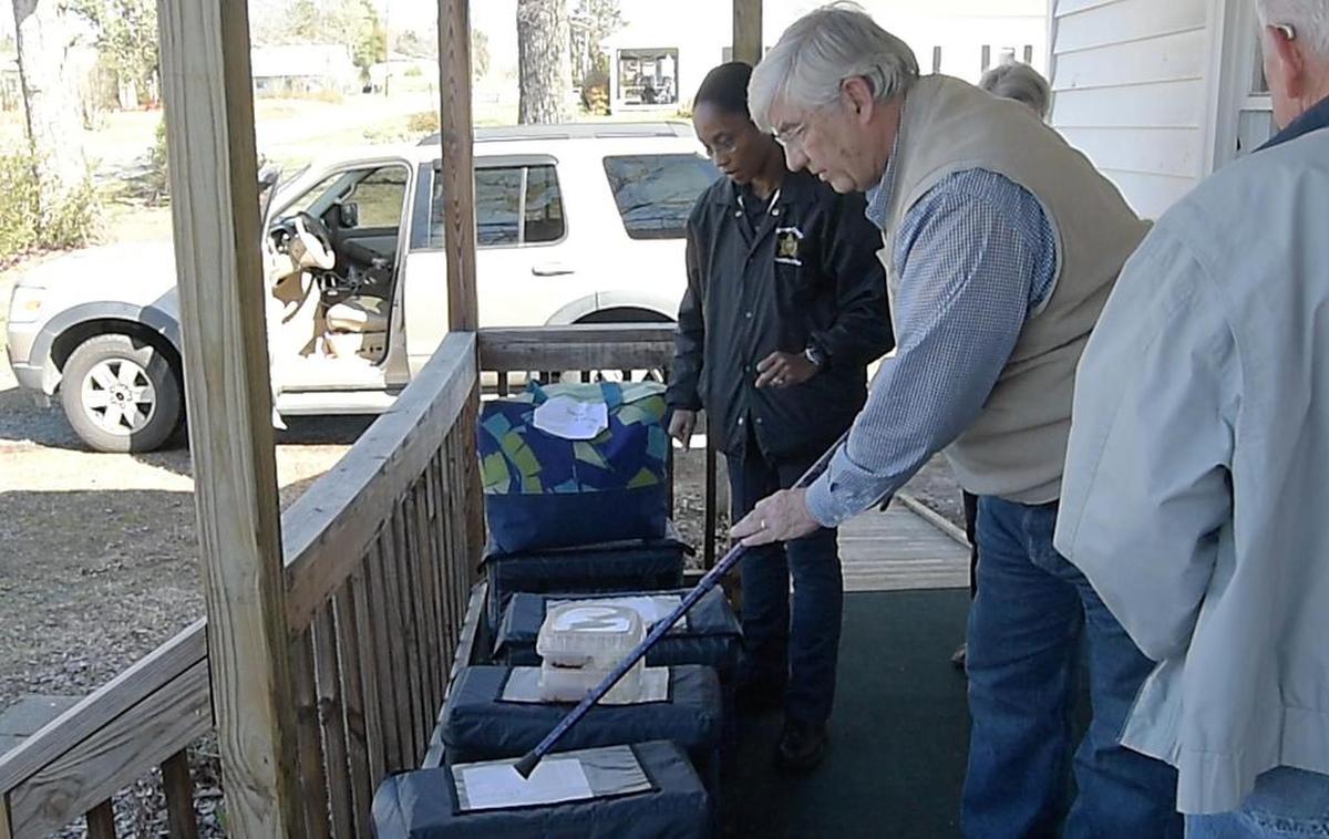 Archie Daniel, a retired captain with the Orange County Sheriff's Office, uses his cane to assign bags of hotdog meals to volunteers with the Orange County Rural Alliance. The volunteers delivered them on Monday, March 26, 2018, to rural seniors.