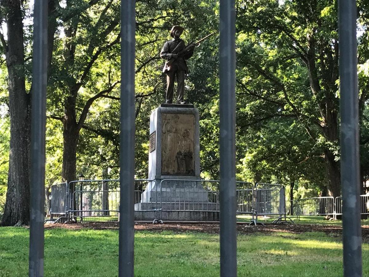 The Confederate memorial Silent Sam stands behind a double barricade as UNC-Chapel Hill prepares for a rally in front of the statue.