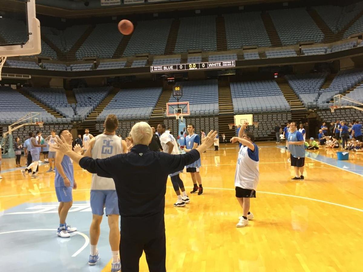 Andrew McKenna gets a shot off at the buzzer as UNC coach Roy Williams (back to camera) raises his arms in anticipation at Sunday’s 15th annual clinic for Special Olympics North Carolina athletes hosted by the UNC basketball program.