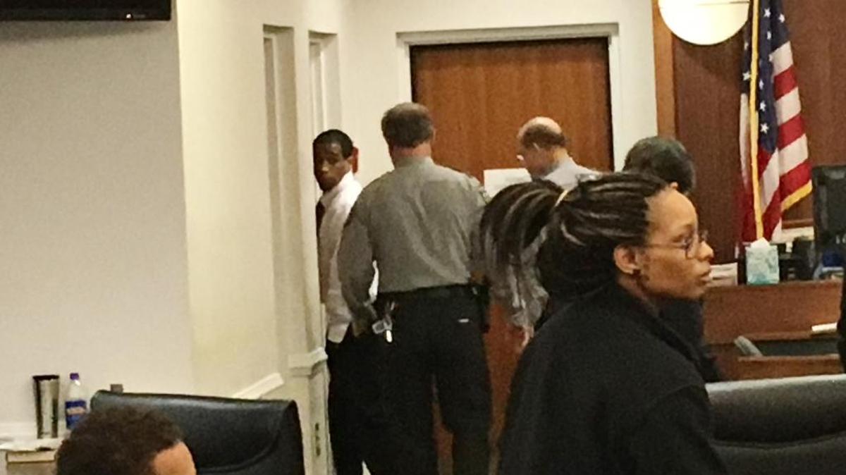Troy Arrington (far left, rear) casts a last glance back at family and friends before exiting the Orange County Courthouse courtroom in which he'd just been sentenced to life in prison for the murder of UNC-Chapel Hill professor Feng Liu.