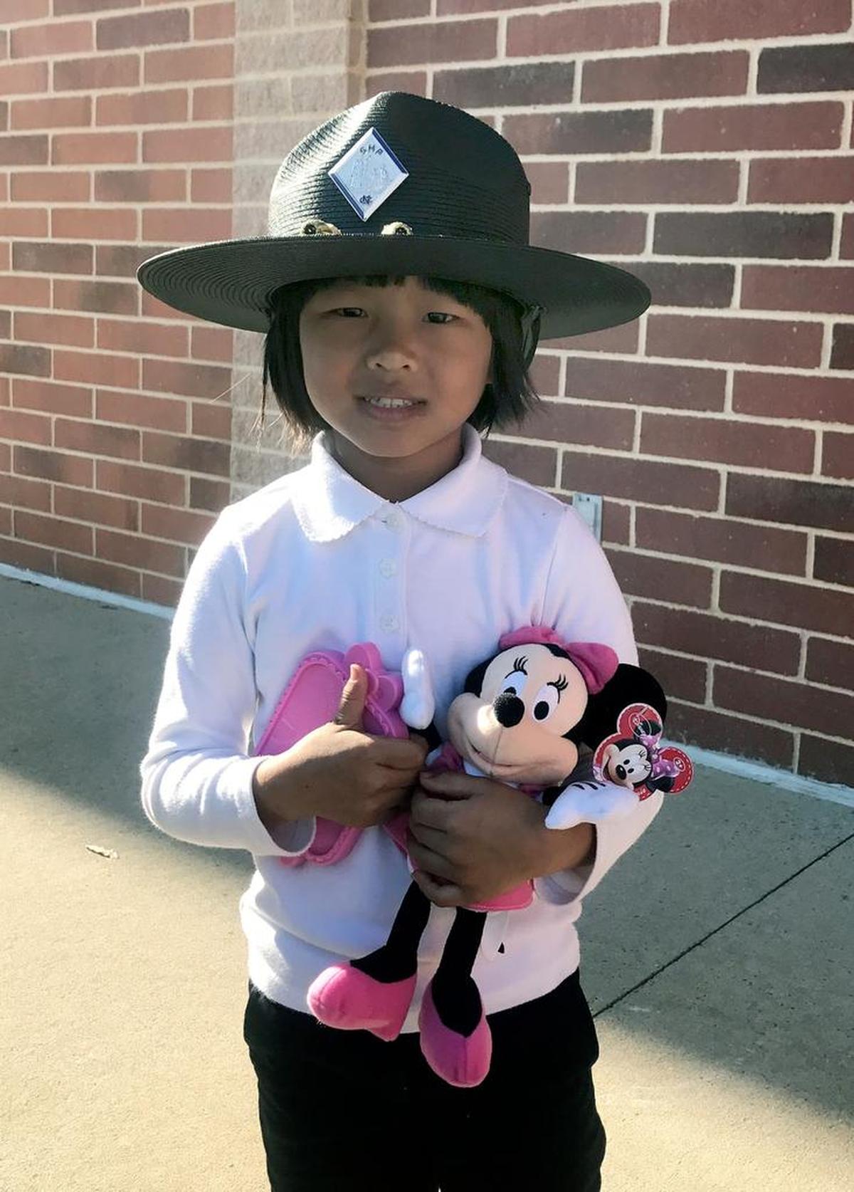 Mary, 5, poses in N.C. Highway Patrol Trooper Michael Dodson’s hat while holding the Minnie Mouse dolls that he gave her after Mary’s family wrecked their car on Interstate 40 on Thursday, Nov. 30, 2017.