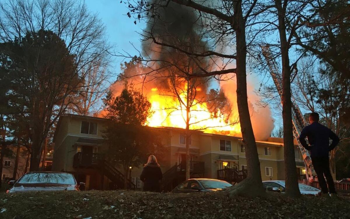 Residents watch Monday, Jan. 8, 2018, as a thick fire burns through eight second-story apartments of Building L at The Villages of Chapel Hill on Smith Level Road in Carrboro. Eight apartments on the building’s ground floor were damaged by smoke and water, fire officials said.