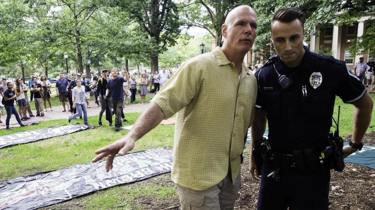 UNC Chapel Hill Chief of Police Jeff B. McCracken escorts one of his officers away from a group of activists after he attempted to stop committed locals from covering the Silent Sam Confederate monument on the campus of UNC Chapel Hill on Aug. 13, 2017.